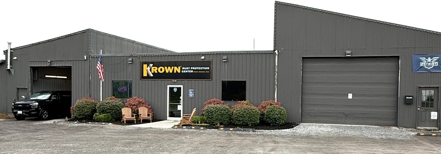 The shop entrance between the two garage bays, with chairs outside