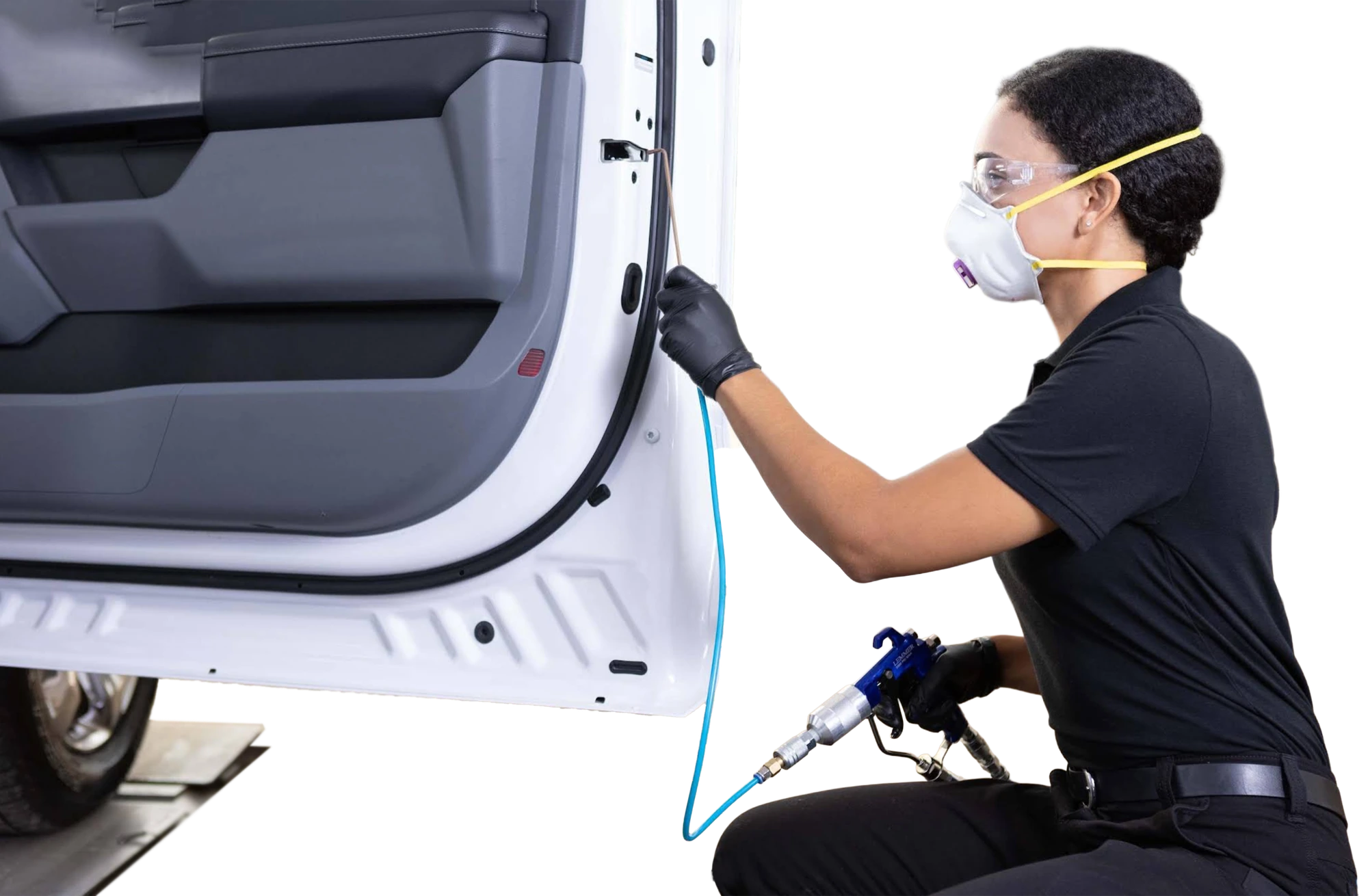 A technician spraying inside an open vehicle door